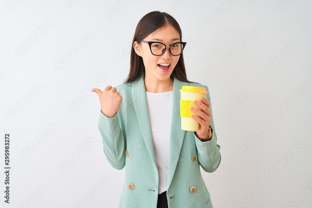 Young chinese woman wearing glasses drinking coffe over isolated white background pointing and showing with thumb up to the side with happy face smiling Young chinese woman wearing glasses drinking coffe over isolated white background pointing and showing with thumb up to the side with happy face smiling