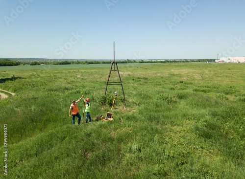 Man and Woman land surveyors a construction site. Young engineers surveyor in helmets give each other five. ..