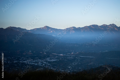 Mist and marine layer creeping in over city in front of San Gabriel Mountains