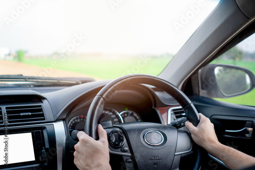 A Man hand holding steering wheel and drive a car for travel