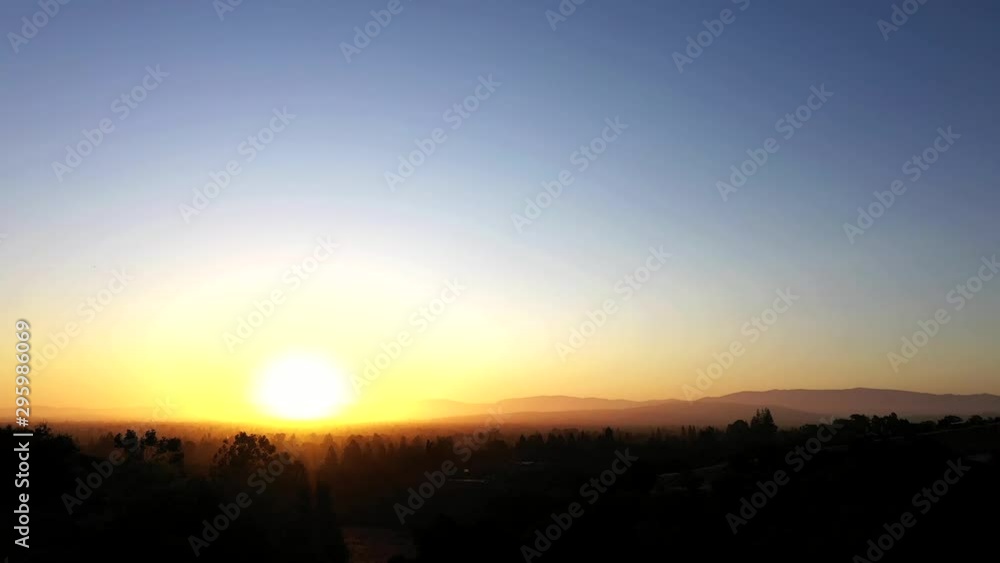 Pan to the right from beautiful sunrise over a smokey fog laden forest in the morning. Full range of colors. Pan to the right from beautiful sunrise over a smokey fog laden forest in the morning. Full range of colors.