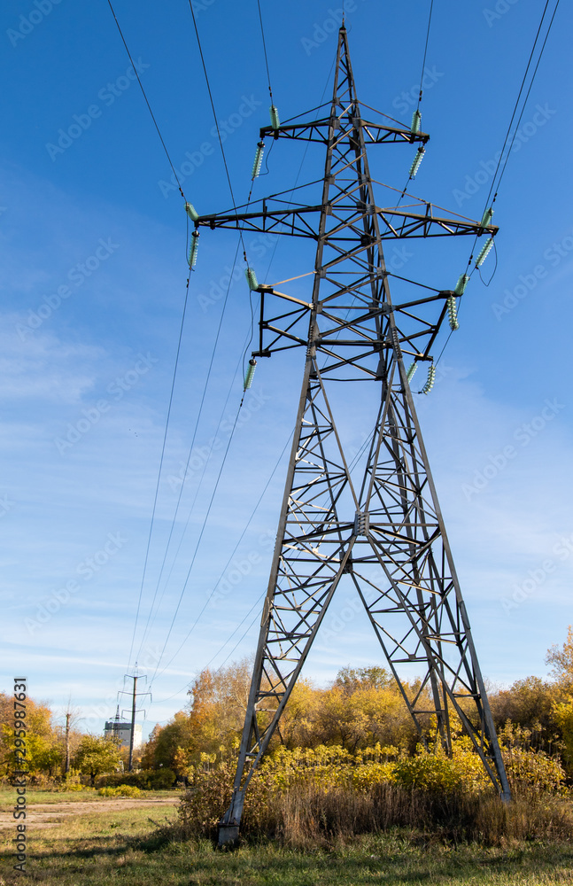 Power lines, insulators and wires. high voltage pylons against the blue ...