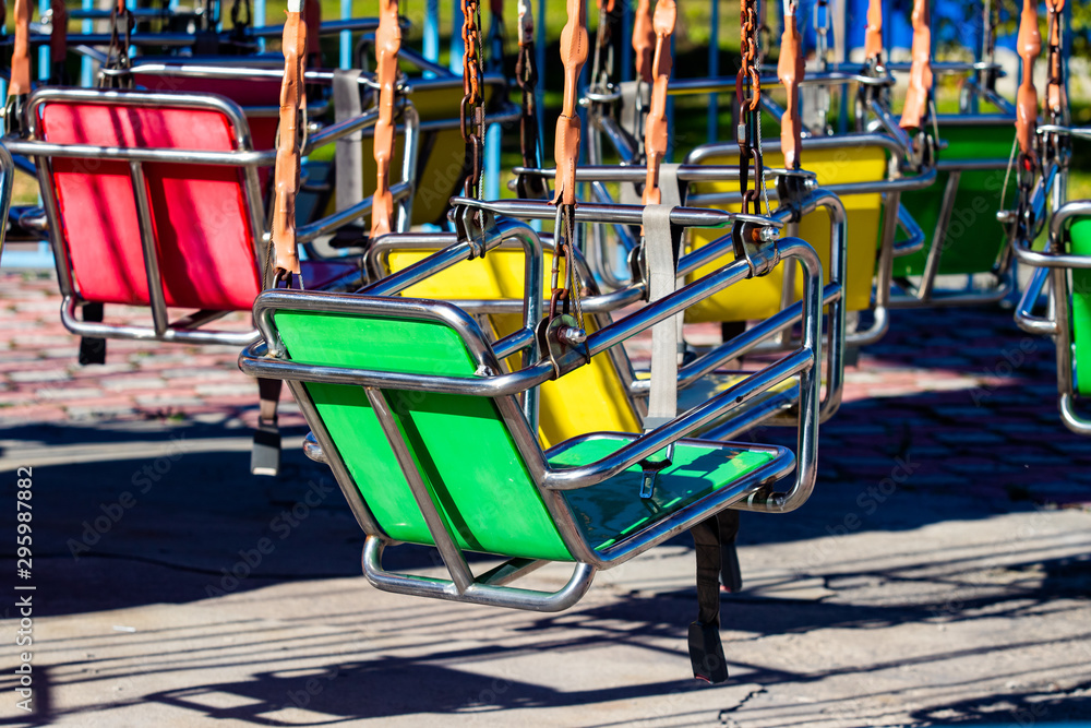 Empty carousel metal seat. Amusement park concept in a city park. Sunny day. Empty carousel metal seat. Amusement park concept in a city park. Sunny day.