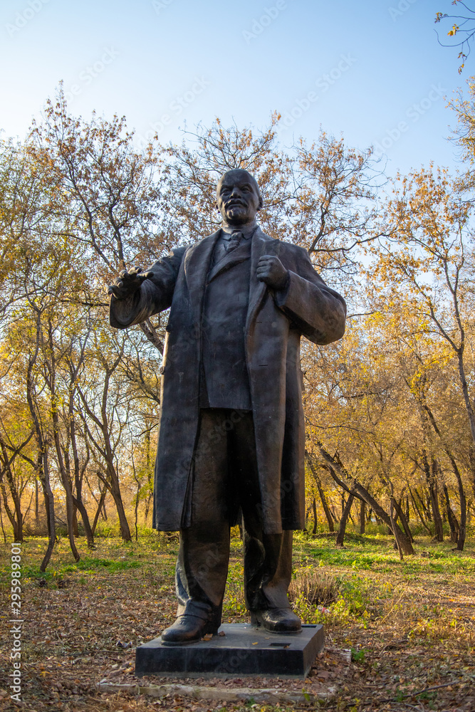 Old abandoned monument to Lenin, a forest in the park.