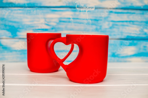 two heart shaped mugs with tea on white background 