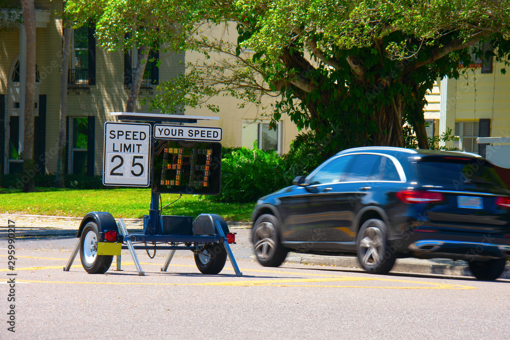 Behang Radar speed limit indicator sign monitored by the police showing 31 miles per hour on the screen proving a passing car is speeding as it drives down the road