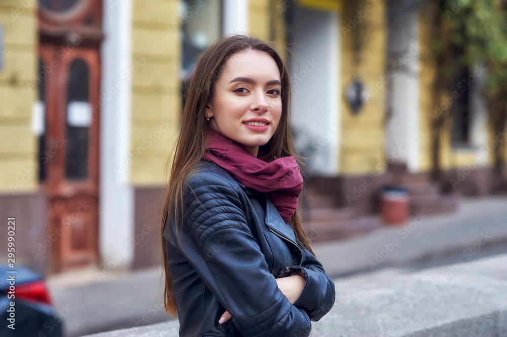 Portrait of a young beautiful woman in the city . Girl in fashionable leather jacket Portrait of a young beautiful woman in the city . Girl in fashionable leather jacket