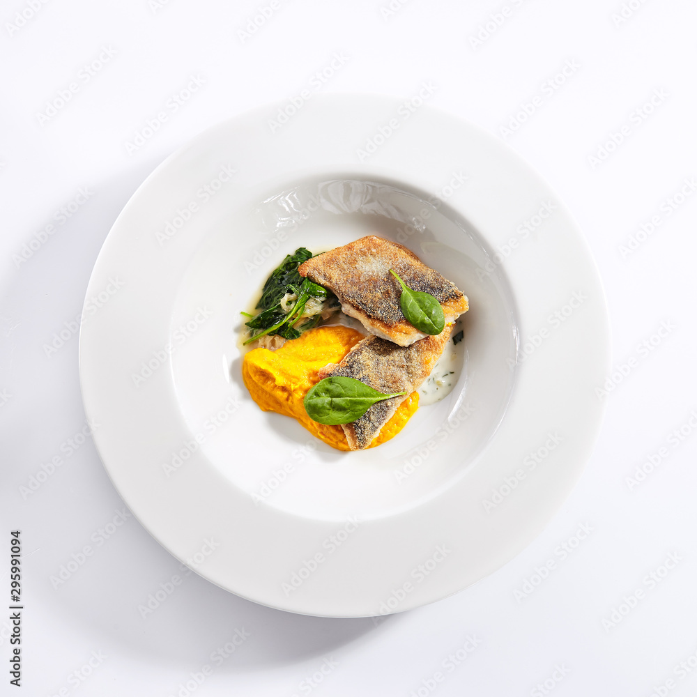 Cod fillet with pumpkin puree and spinach top view