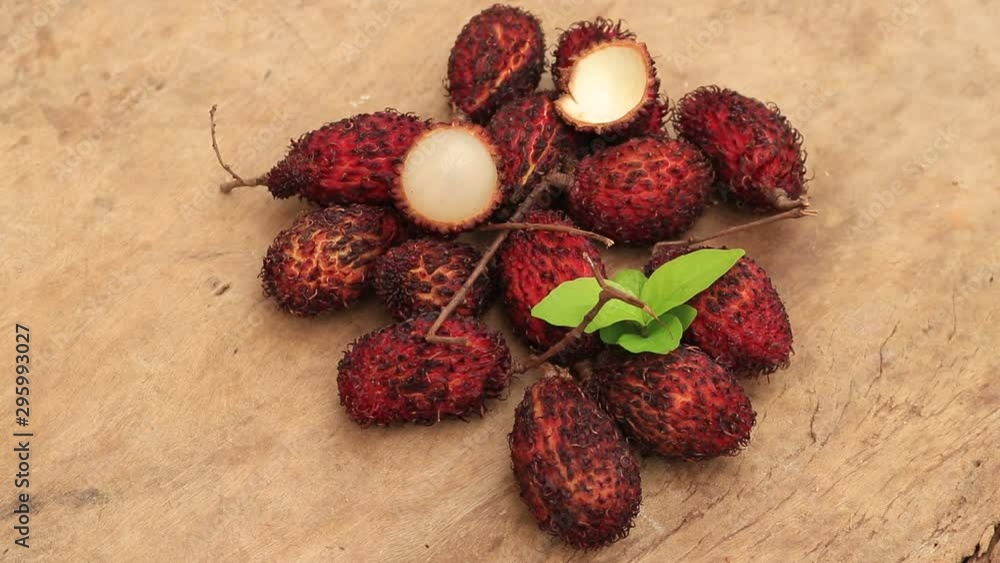 Lychee with leaves isolated on wood background. Lychee with leaves isolated on wood background.
