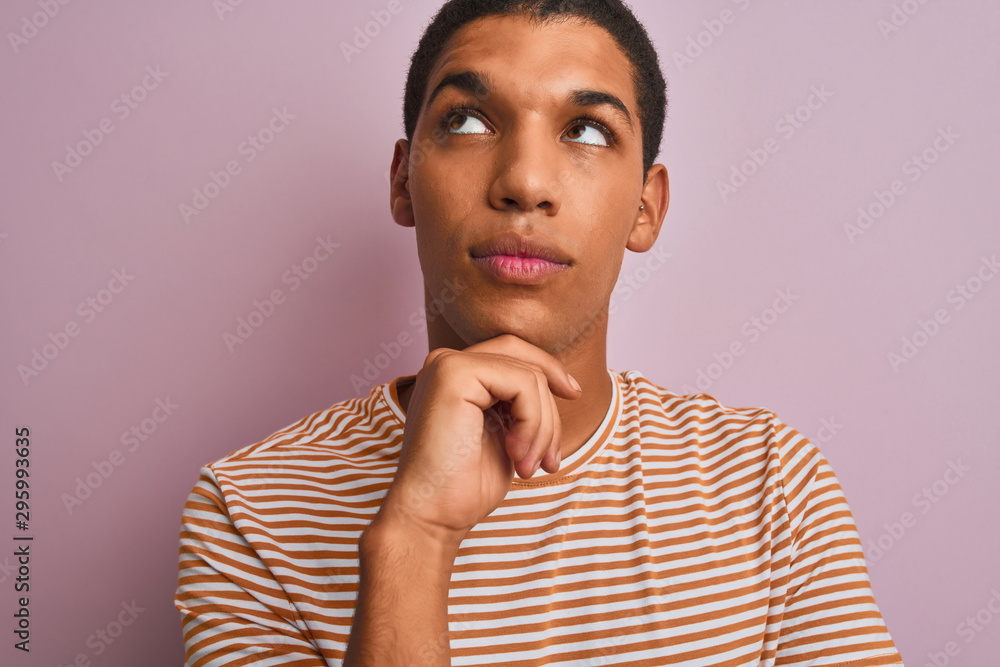 Young handsome arab man wearing striped t-shirt standing over isolated pink background serious face thinking about question, very confused idea Young handsome arab man wearing striped t-shirt standing over isolated pink background serious face thinking about question, very confused idea
