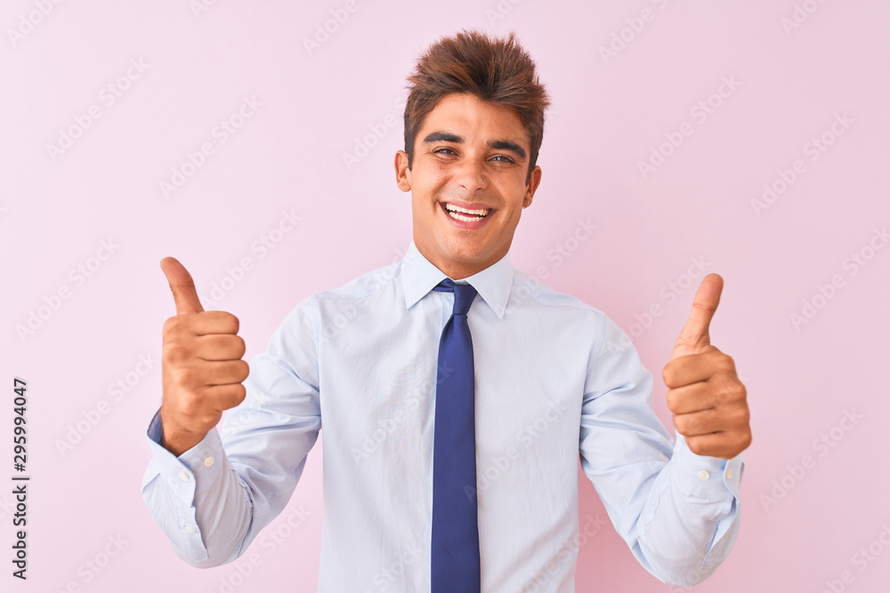 Young handsome businessman wearing shirt and tie standing over isolated pink background success sign doing positive gesture with hand, thumbs up smiling and happy. Cheerful expression Young handsome businessman wearing shirt and tie standing over isolated pink background success sign doing positive gesture with hand, thumbs up smiling and happy. Cheerful expression