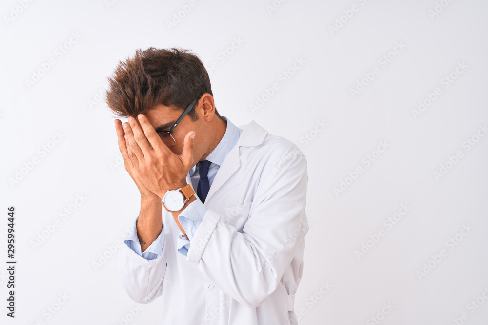Young handsome sciencist man wearing glasses and coat over isolated white background with sad expression covering face with hands while crying. Depression concept. Young handsome sciencist man wearing glasses and coat over isolated white background with sad expression covering face with hands while crying. Depression concept.