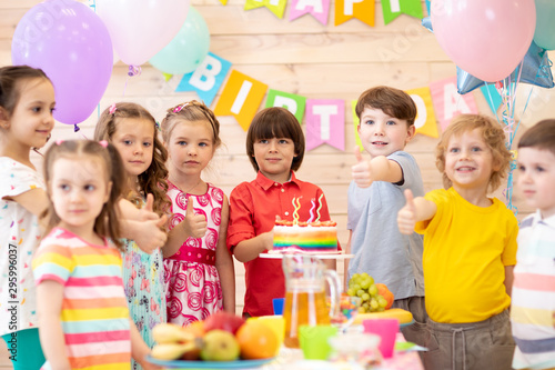 Group of preschool children celebrating birthday party together in kindergarten