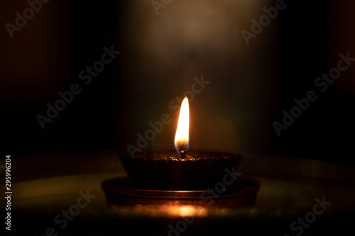 Concept of Light in darkness showing with Diwali terracotta Diya ot light lamp in dark.