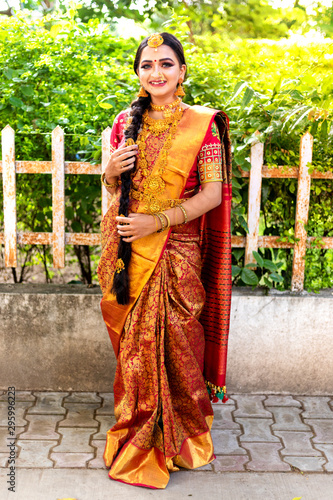 Full length Portrait of an Indian model in traditional wedding dress or Sari and heavy gold jewelry 