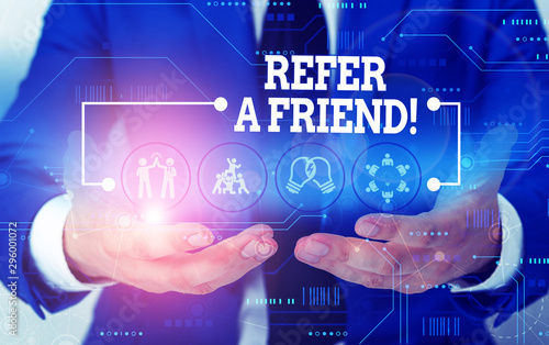 Conceptual hand writing showing Refer A Friend. Concept meaning direct someone to another or send him something like gift Male wear formal suit presenting presentation smart device photo