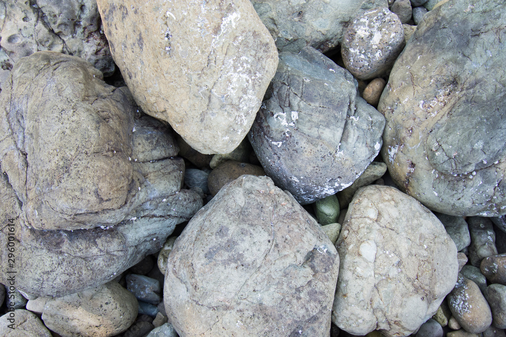 Stacked rounded stones at sea. Small polished pebbles stack on dark wet rock Stacked rounded stones at sea. Small polished pebbles stack on dark wet rock