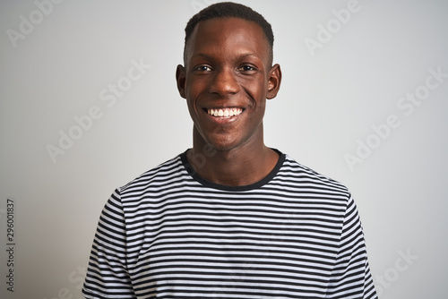African american man wearing navy striped t-shirt standing over isolated white background with a happy face standing and smiling with a confident smile showing teeth