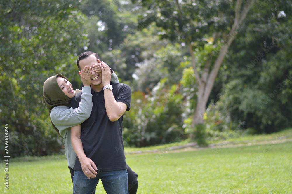 Happy Muslim young couple of lovers enjoy life moments. Hijab woman covering her boyfriend eyes to surpised Handsome man spending time together Happy Muslim young couple of lovers enjoy life moments. Hijab woman covering her boyfriend eyes to surpised Handsome man spending time together