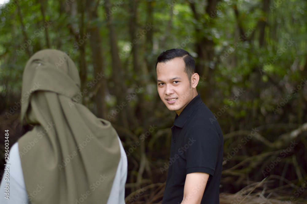 Happy young muslim couple on tropical forest with mangrove Happy young muslim couple on tropical forest with mangrove