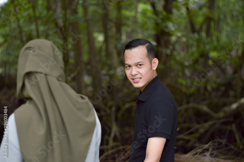 Happy young muslim couple on tropical forest with mangrove