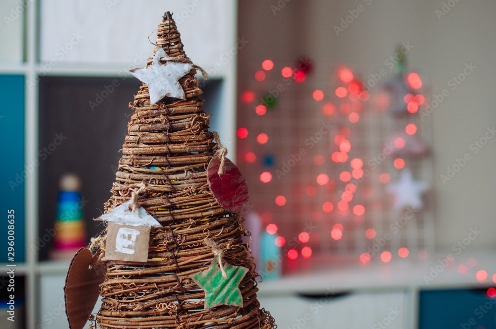 Close up of kids handmade corrugated cardboard decorations on wooden Christmas tree Close up of kids handmade corrugated cardboard decorations on wooden Christmas tree
