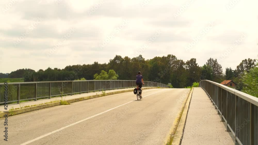 A man travelling with a touring bicycle through bridge. A man travelling with a touring bicycle through bridge.