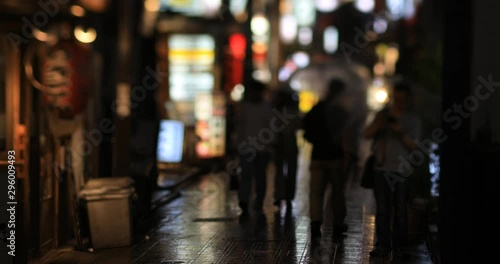 Walking people at the downtown neon street in Nakano Tokyo rainy day