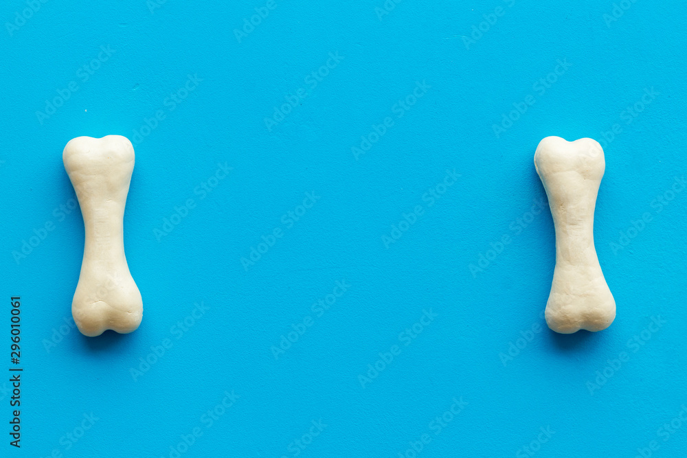 Food and toys for dogs. Chewing bones on blue background top view space for text Food and toys for dogs. Chewing bones on blue background top view space for text