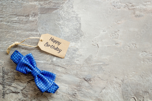 Men's birthday concept. Happy birthday text and bow tie on grey background top view copy space photo