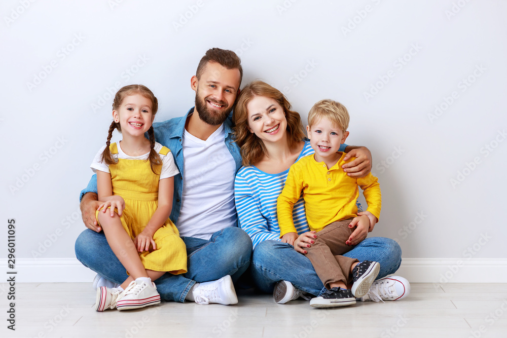 happy family mother father and children daughter and son near an grey blank wall. happy family mother father and children daughter and son near an grey blank wall.