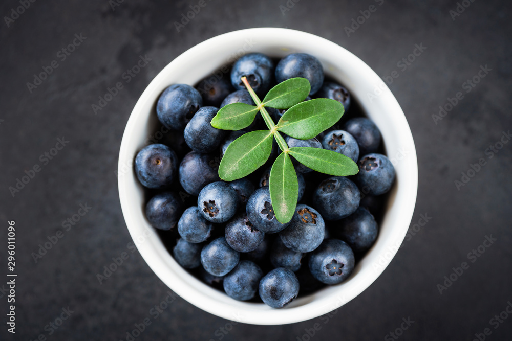 Fresh blueberries in bowl on black background, table top view Fresh blueberries in bowl on black background, table top view