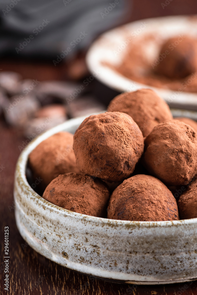 Chocolate truffles pile in a bowl covered in raw cocoa powder. Healthy vegan chocolate truffles, energy balls. Closeup view Chocolate truffles pile in a bowl covered in raw cocoa powder. Healthy vegan chocolate truffles, energy balls. Closeup view