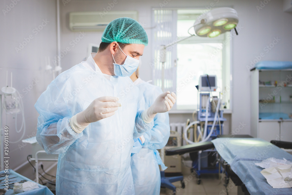 Medical assistant helps a surgeon. Medical assistant helps a surgeon.