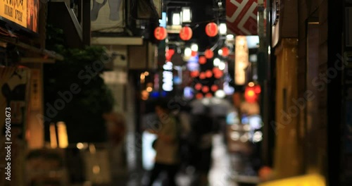 Walking people at the downtown neon street in Nakano Tokyo rainy day