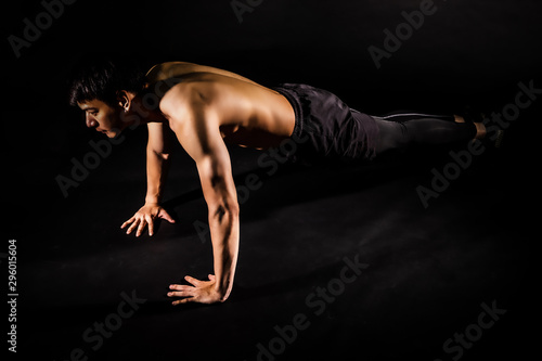 Fototapeta Naklejka Na Ścianę i Meble -  sport man at fitness gym club doing push up exercise for body and showing muscle bodybuilding on black backgrounds, fitness concept, sport concept