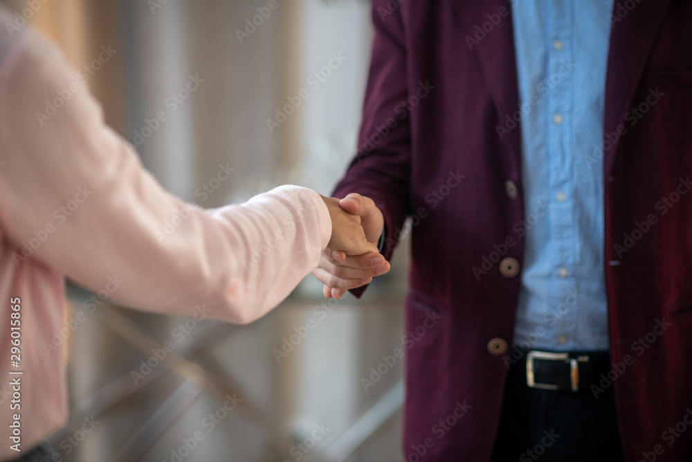 Psychoanalyst wearing dark jacket shaking hand of client