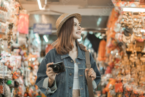 Smiling woman traveler in chiangmai market landmark chiangmai thailand holding camera with backpack on holiday  relaxation concept  travel concept