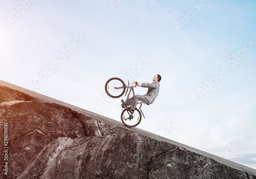 Businessman riding downhill by bike