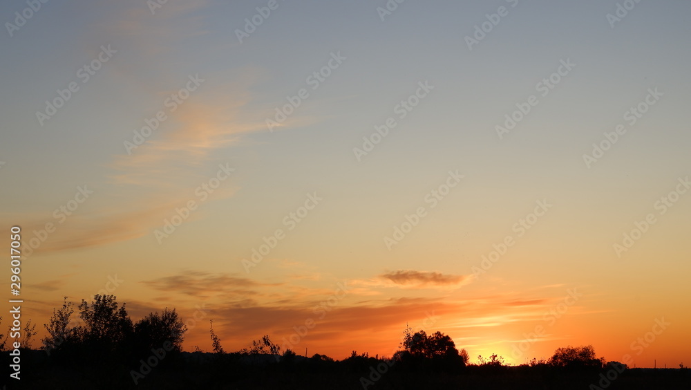 Happy new day concept: summer sunrise over beautiful field and stunning sky