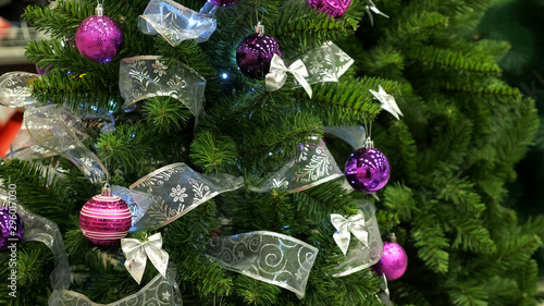 wonderful artificial christmas tree with bright sparkling decorations and shining garlands in shop extreme close view