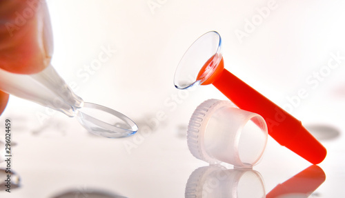 Tableau sur toile Fingers catching a contact lens and an applicator on table