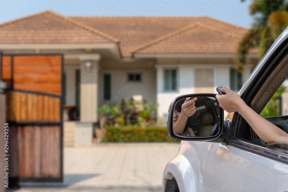 Fotografie Woman in car, hand opening the automatic gate by using remote control