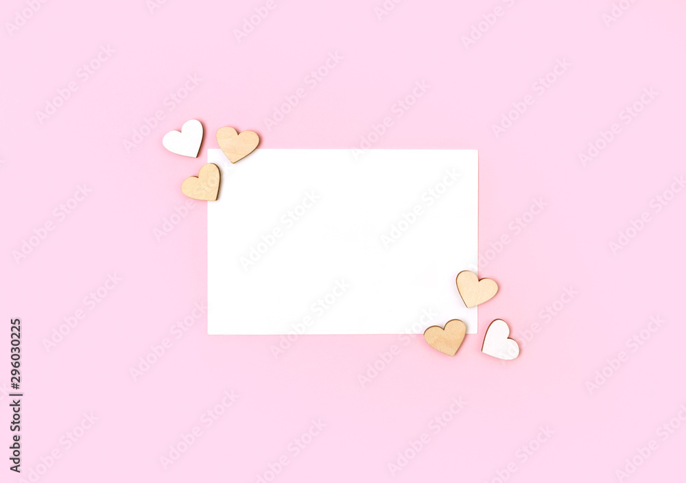 Letter or greeting card with wooden hearts on pastel pink background Letter or greeting card with wooden hearts on pastel pink background