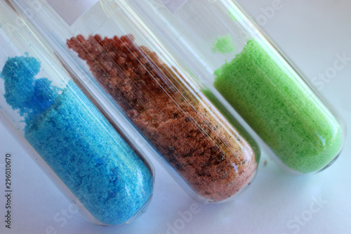Crystal salts hydrates in test tubes: blue copper sulfate, brown cobalt sulfate, green nickel chloride. photo