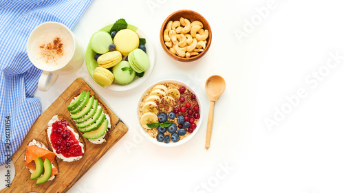 breakfast top view isolate white background. oatmeal with berries, toasts on a wooden tray, nuts, coffee