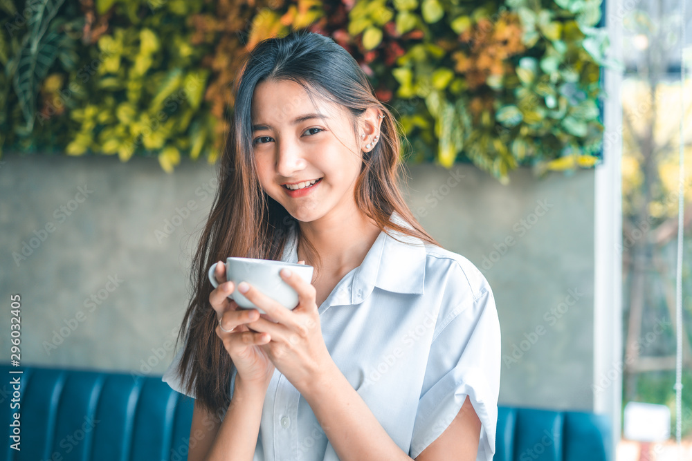 Asian woman in a cafe drinking coffee .Portrait of Asian woman smiling in coffee shop cafe vintage colour tone. Asian woman in a cafe drinking coffee .Portrait of Asian woman smiling in coffee shop cafe vintage colour tone.
