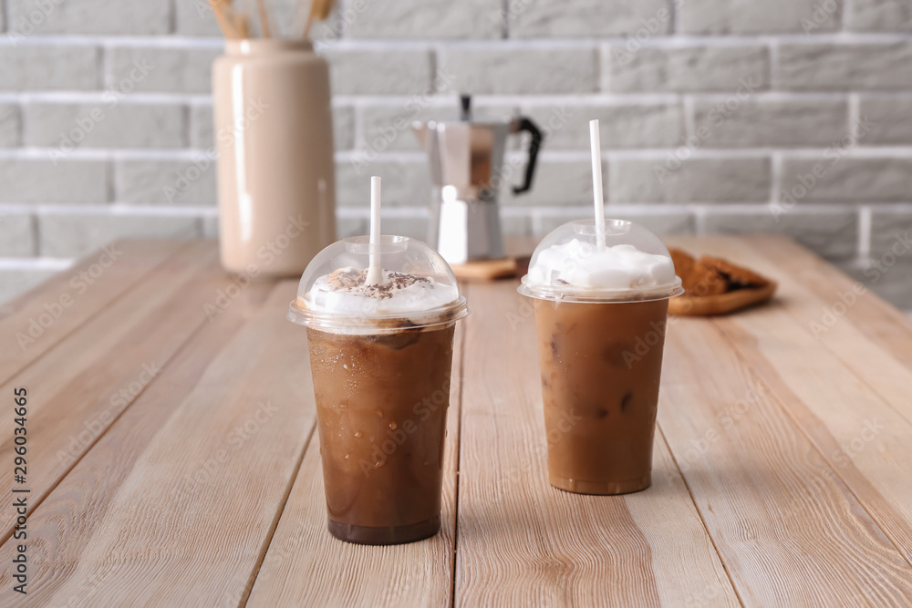 Cups of tasty frappe coffee on wooden table Cups of tasty frappe coffee on wooden table