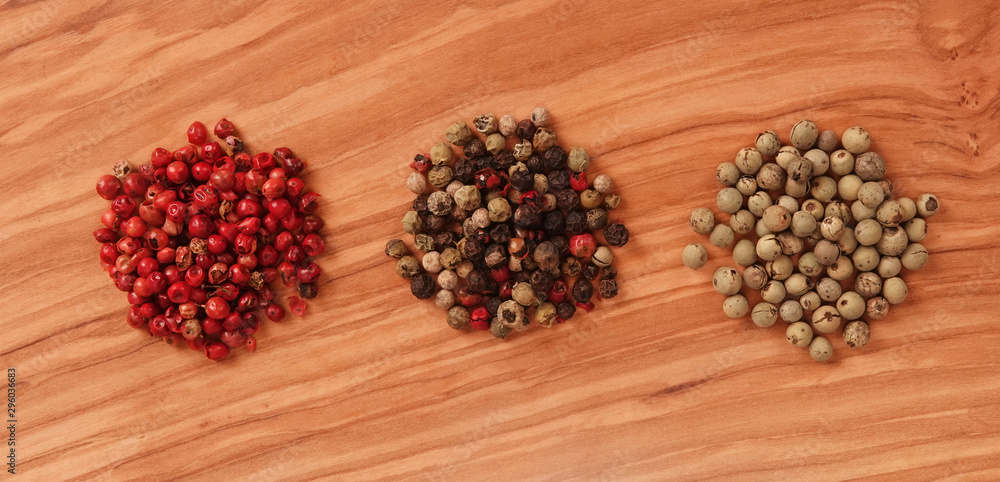Three different pepper seeds piles on background brown wooden lovely board classic cooking concept Three different pepper seeds piles on background brown wooden lovely board classic cooking concept