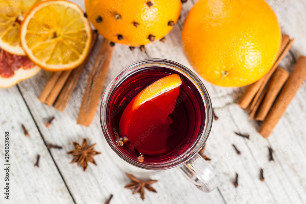 Glass of delicious mulled wine with oranges anise cinnamon on white wooden table Glass of delicious mulled wine with oranges anise cinnamon on white wooden table